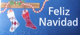 tarjeta de navidad con dos calcetines colgados, con texto feliz navidad y debajo el mismo texto en braille
