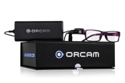 Caja del dispositivo y encima unas gafas con el OrCam incorporado