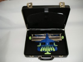 Mquina de escribir braille con carcasa azul y teclas verdes dentro del maletn de transporte negro