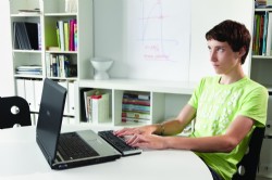 Un joven manejando la lnea braille delante de un PC