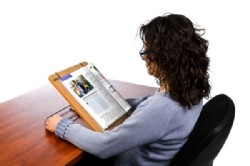 Mujer de espaldas mirando un libro colocado en un atril modelo 100 de color roble