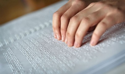 Manos leyendo un libro en braille