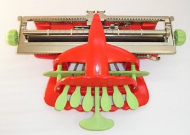 Máquina de escribir braille con carcasa roja y teclas verdes